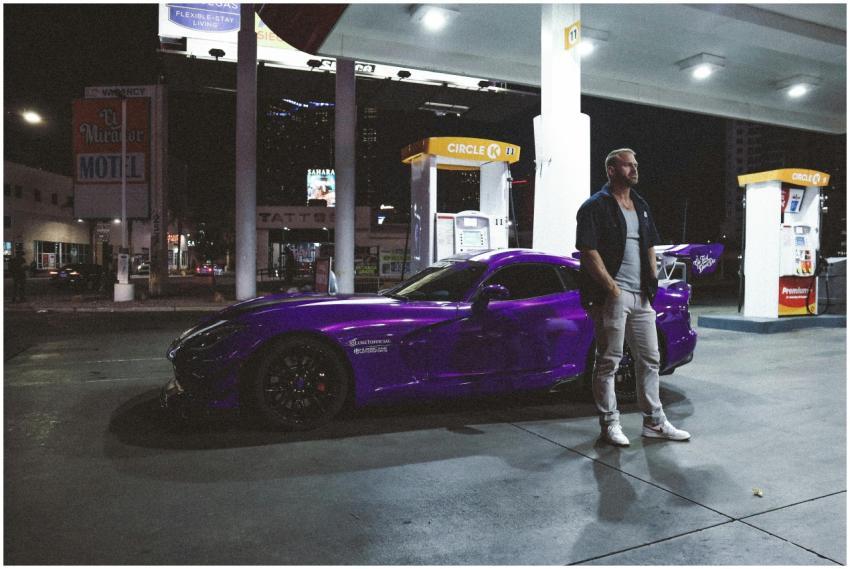 Night scene of a man standing beside a purple spor