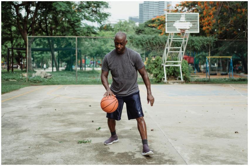 An adult man skillfully dribbles a basketball on a