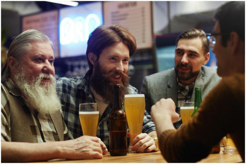 Group of cheerful friends enjoying beer and conver