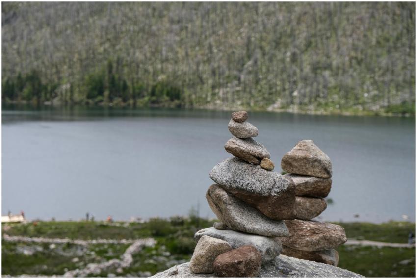 A peaceful stone stack by a calm lake in China, pe