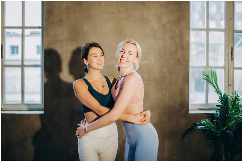 Two women in sportswear, embracing with smiles in