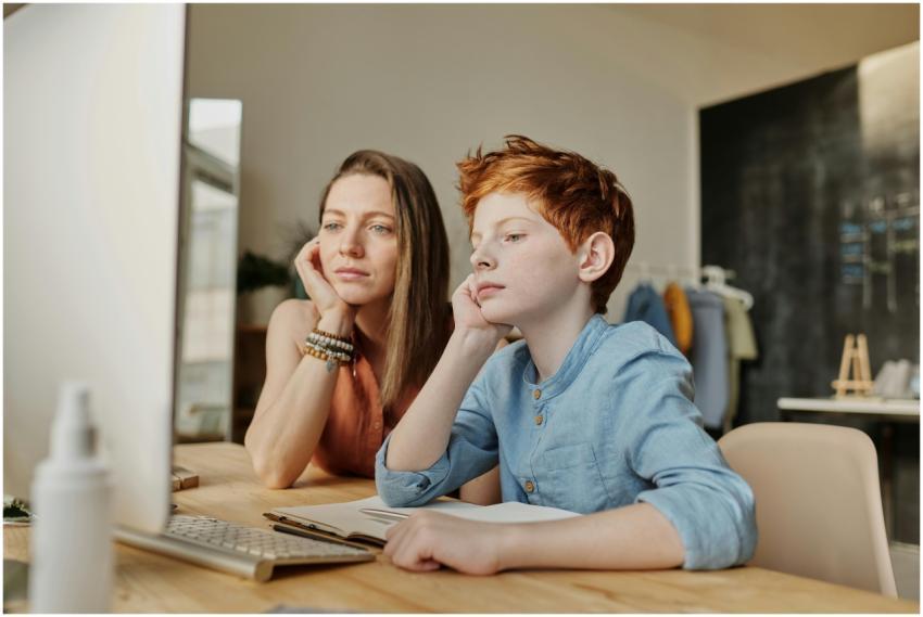 A mother and son engaged in online learning at hom