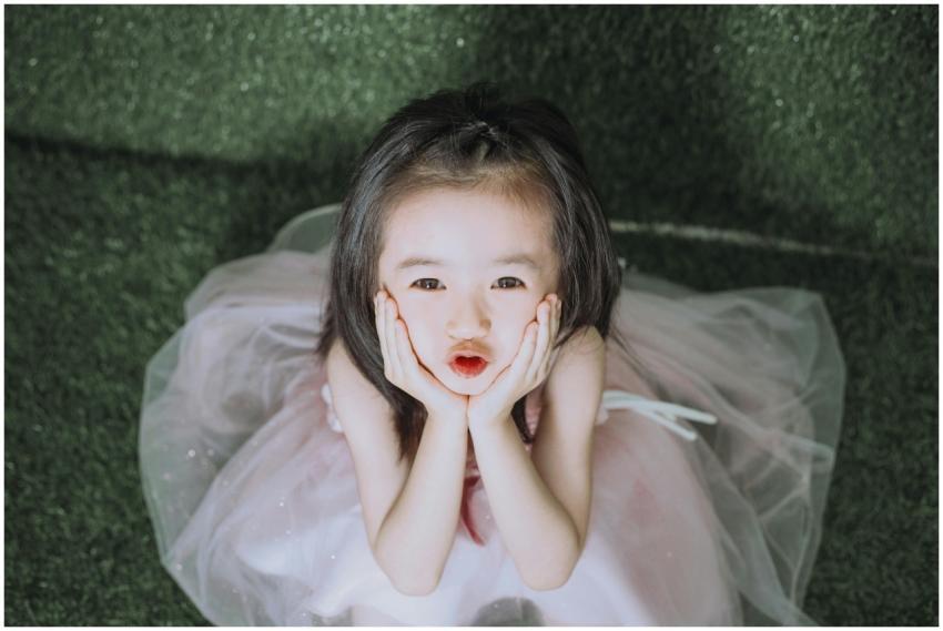 Charming young girl in a cute dress making a playf