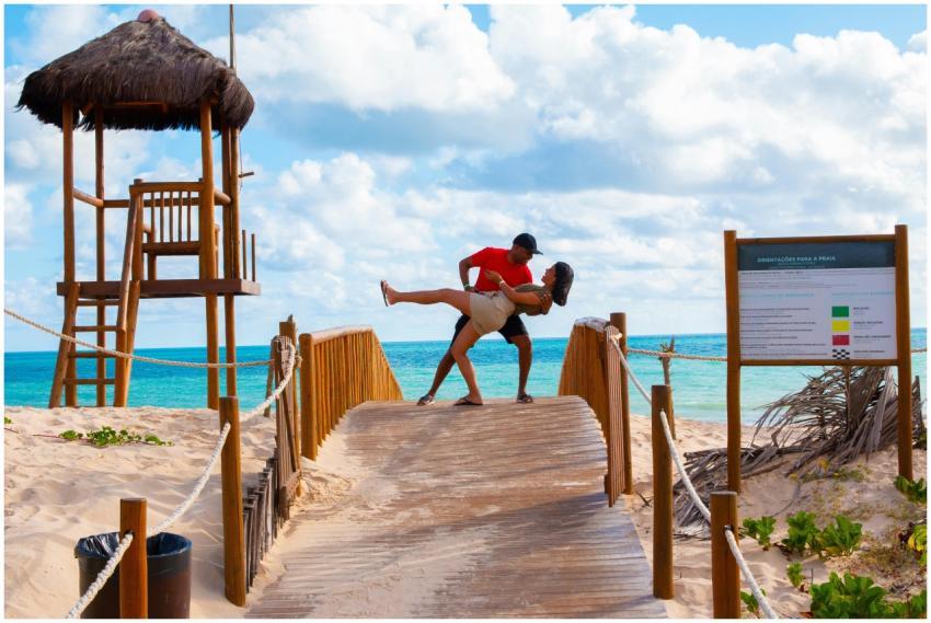 Couple embracing on a wooden bridge at a beach in