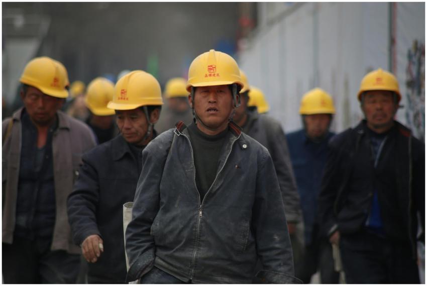 Construction workers in hard hats walking at a sit