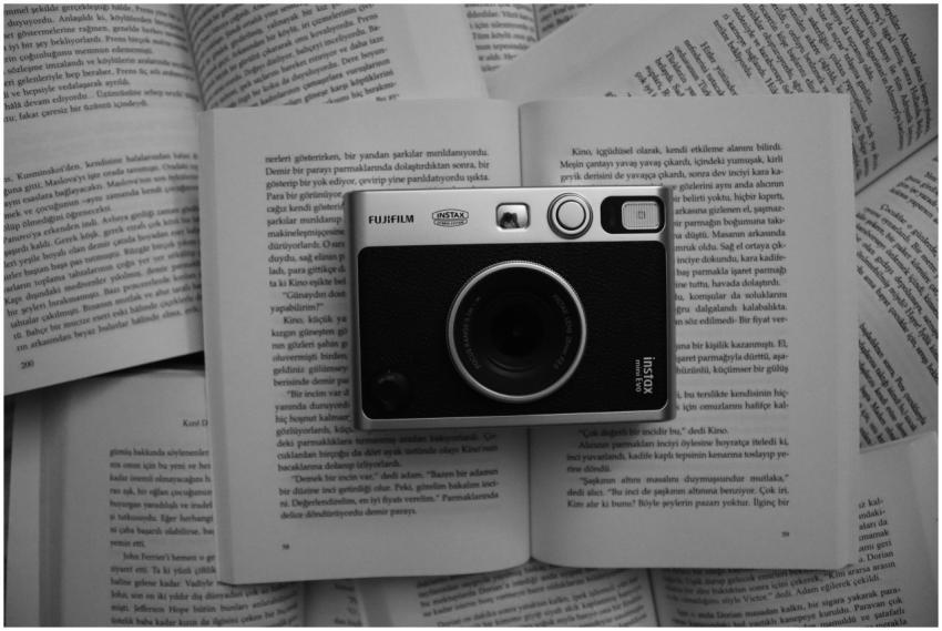 A vintage Fujifilm instant camera placed on open b