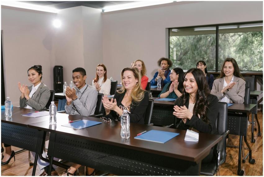 A diverse group of adults applauding in a business