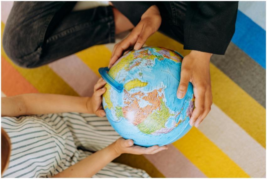 Two children exploring a colorful globe, focusing