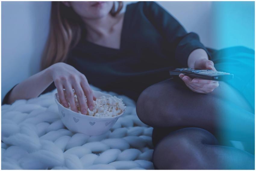 Cozy evening scene with woman enjoying popcorn and
