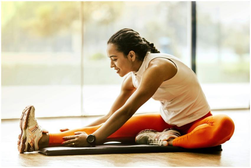 A woman enjoying a yoga stretch indoors, promoting