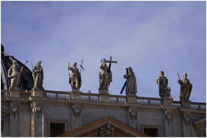 Statues atop St. Peter's Basilica under clear blue