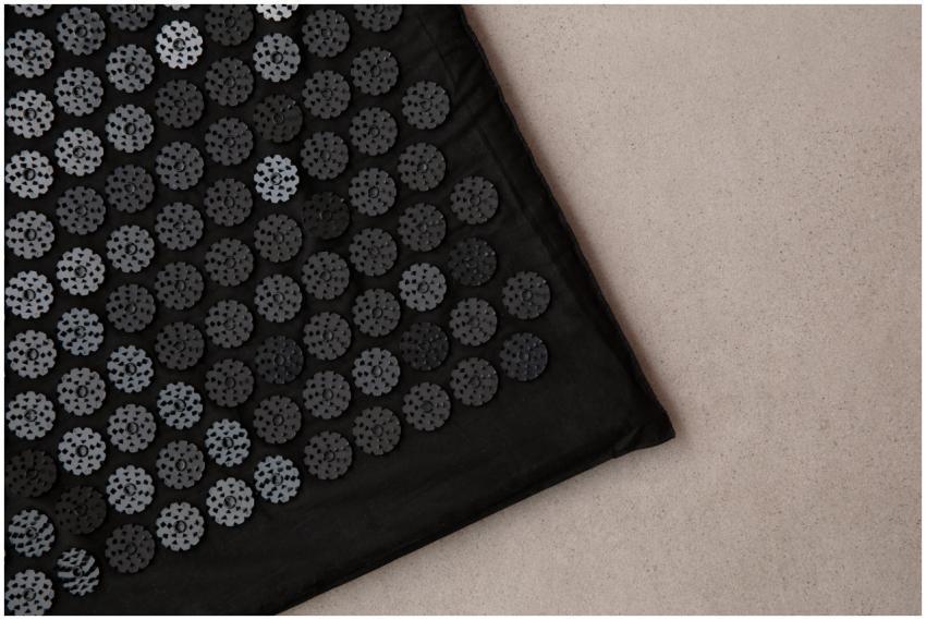 Detailed view of a black acupuncture mat on a neut