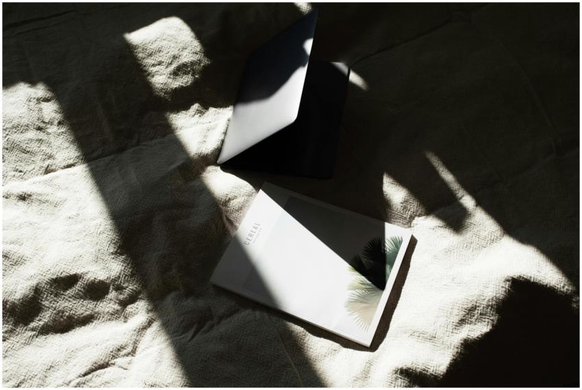 From above of opened laptop and book placed togeth