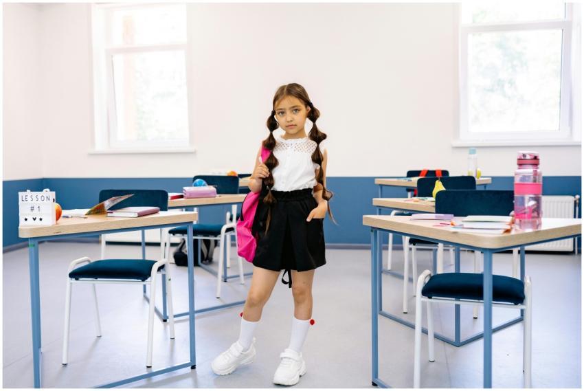 A young girl stands confidently in a bright, moder