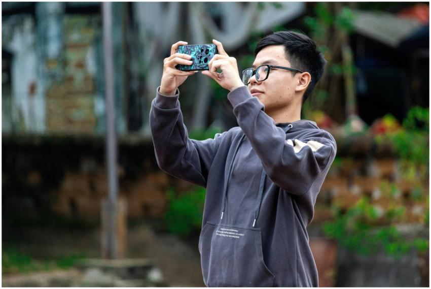 A young man captures a moment with his smartphone