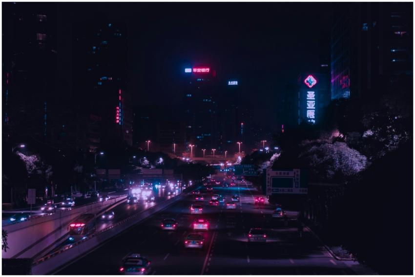 Illuminated city street with vibrant lights and tr