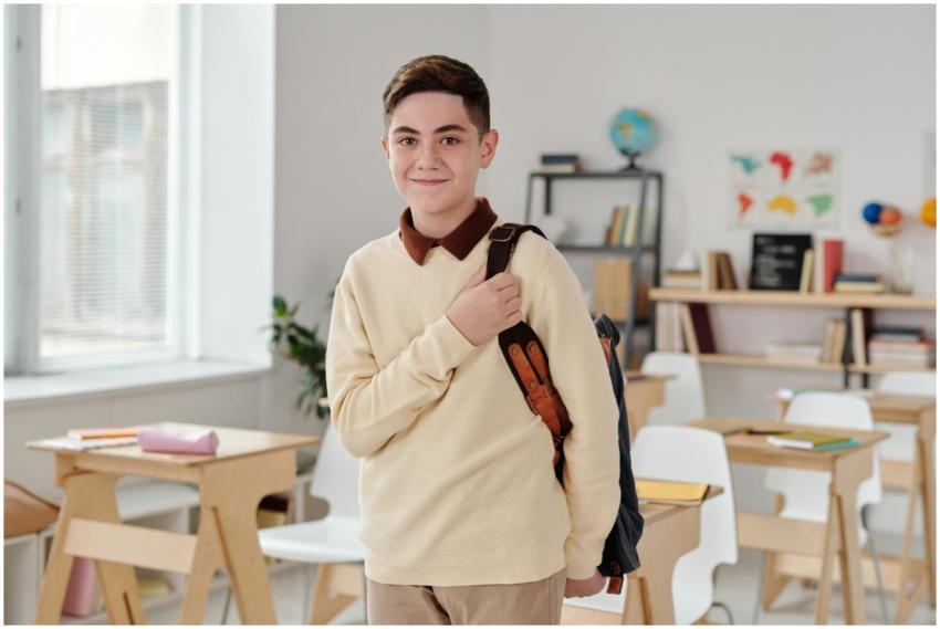A smiling schoolboy confidently standing in a mode