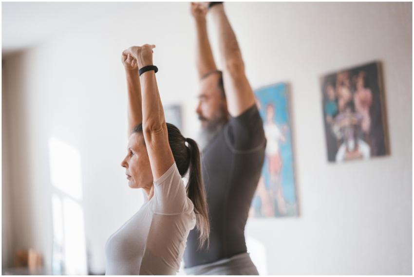Elderly couple stretching together indoors for a h