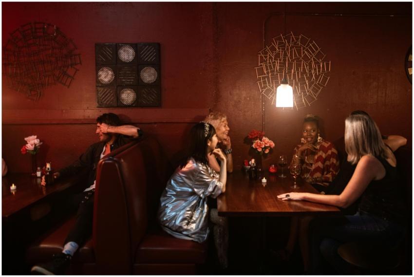 Group of adults enjoying drinks at a dimly lit bar