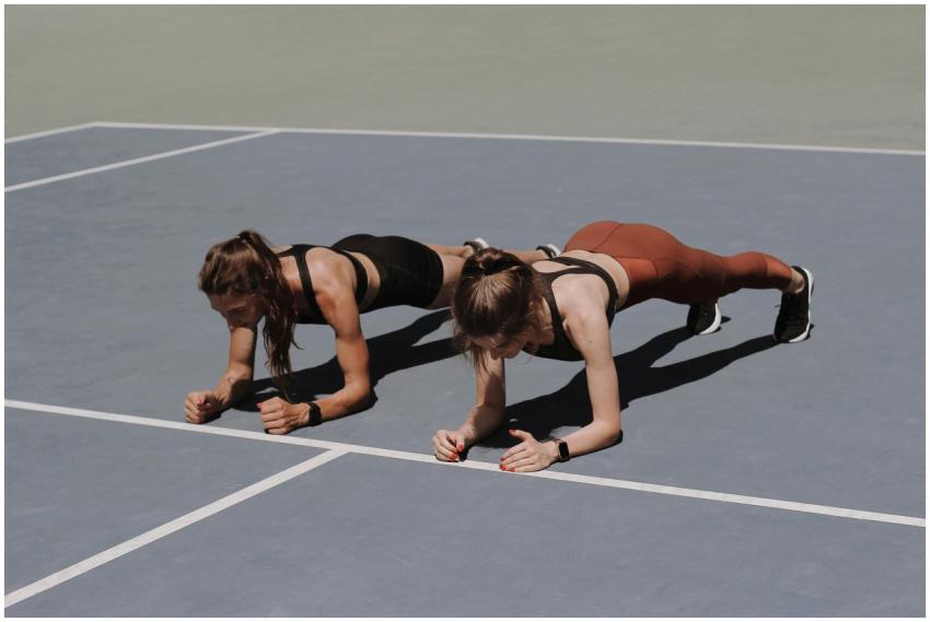 Two women in activewear doing plank exercises on a