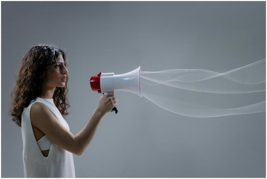 Woman using a megaphone emitting sound waves on a