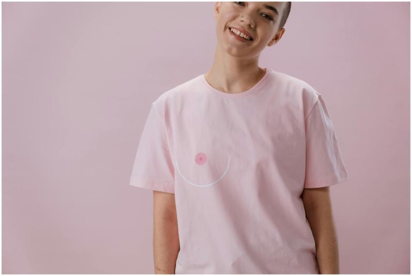 Smiling person in pink shirt symbolizing breast ca
