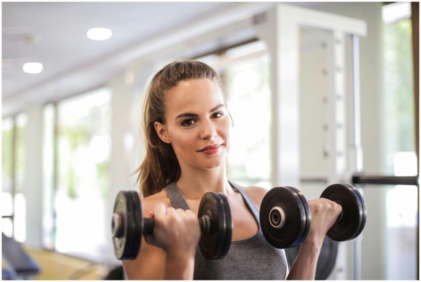 Woman exercising with dumbbells in a bright, moder