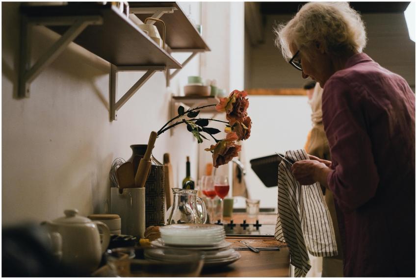 Elderly woman engaged in dish drying in a cozy, ho