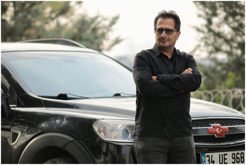 A man wearing glasses and a black shirt stands con