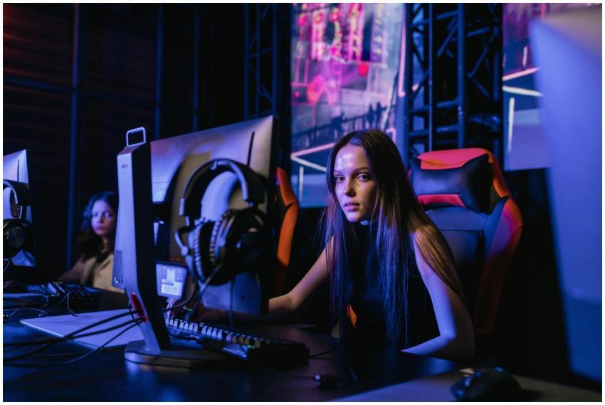 A young woman engages deeply in a video game at an