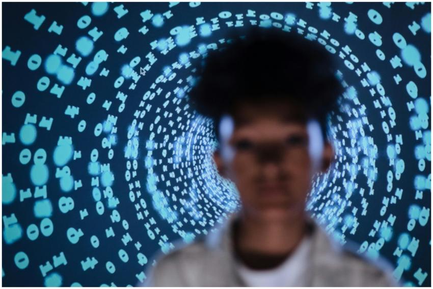 Blurred person in front of a digital code projecti