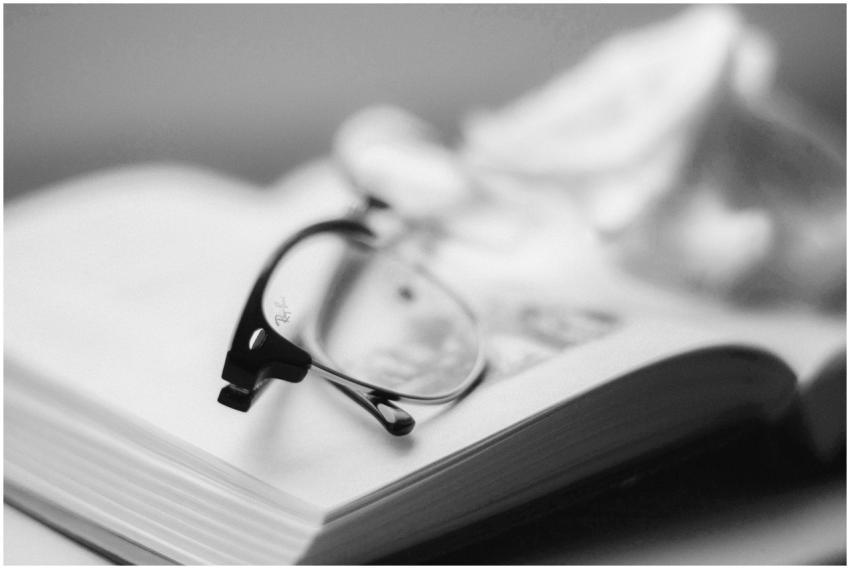 Black and white photo of eyeglasses on an open boo
