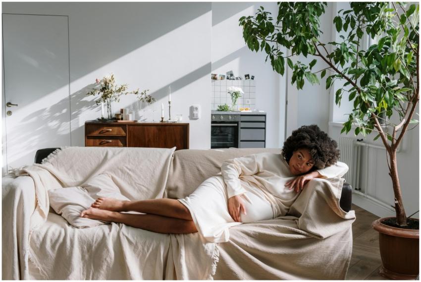 Pregnant woman relaxing on a sofa in a warm, Scand
