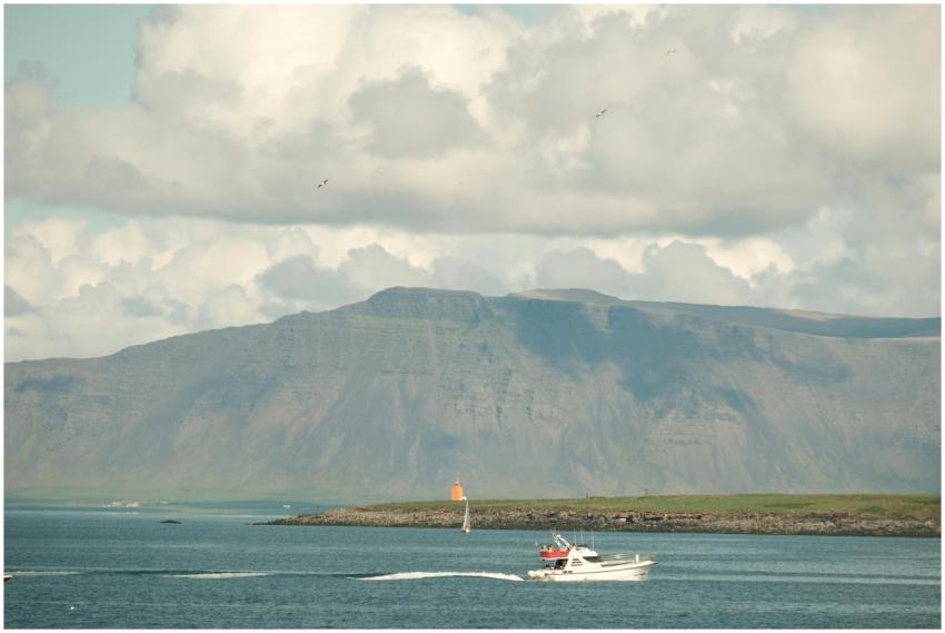 A peaceful view of Reykjavík's coastline with a bo