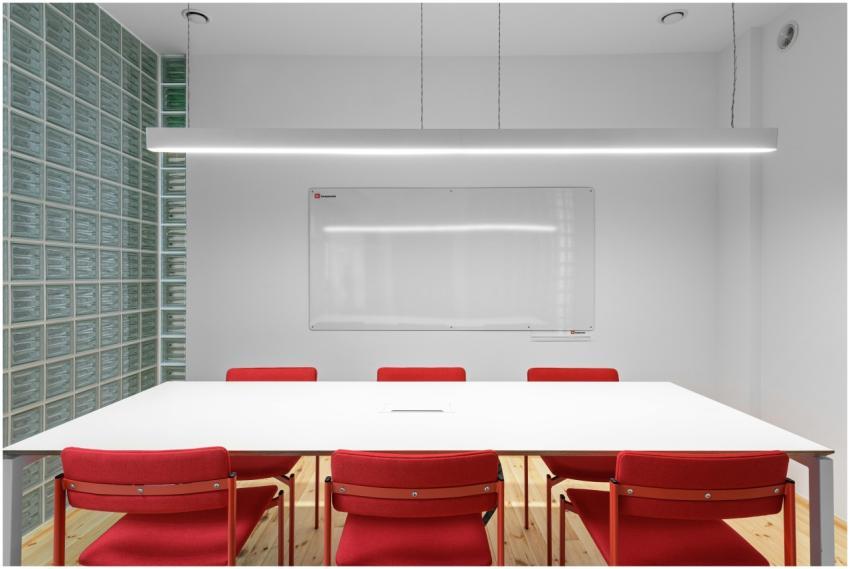Interior of office with white table near red stool
