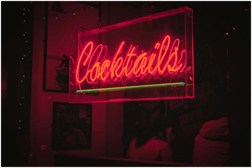 Bright neon 'Cocktails' sign glowing in a lively D
