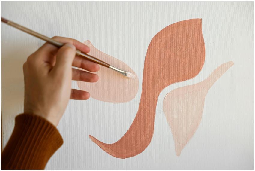 Close-up of a hand painting abstract shapes on can