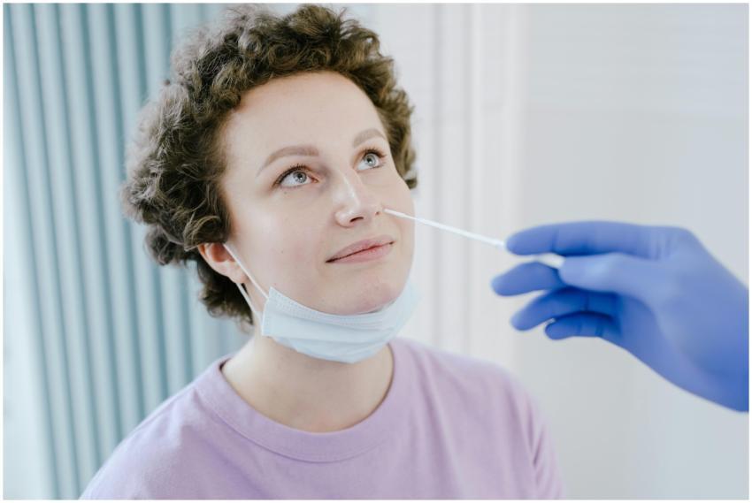 A woman in a medical facility receiving a nasal sw