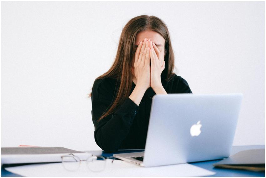 Woman feeling stressed and overwhelmed at her desk