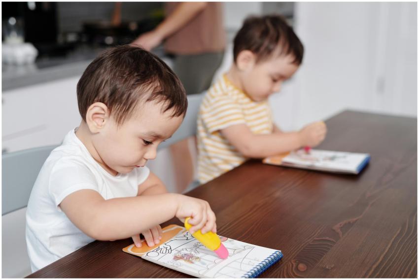 Two young boys immersed in coloring with crayons a
