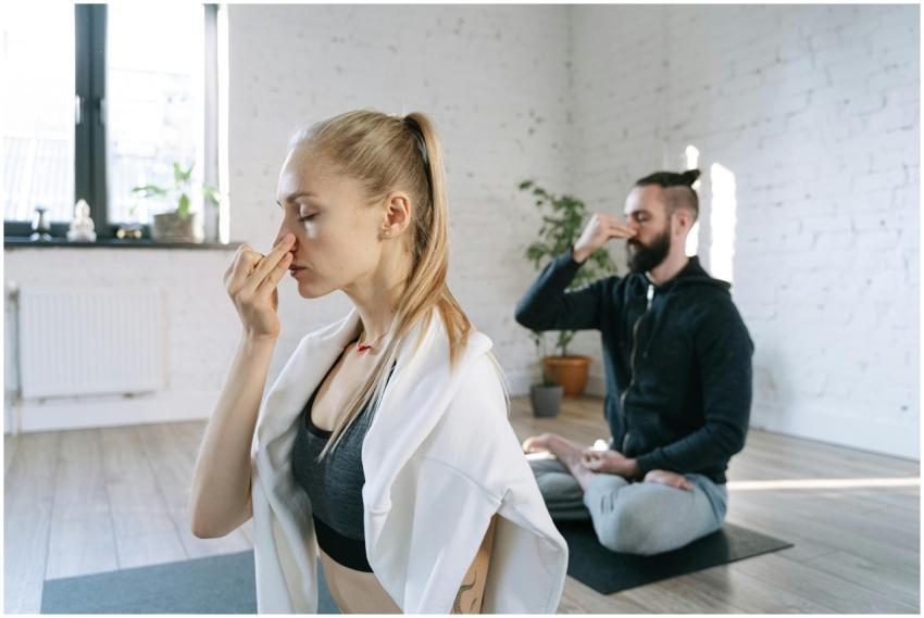 Two individuals practicing mindful breathing yoga