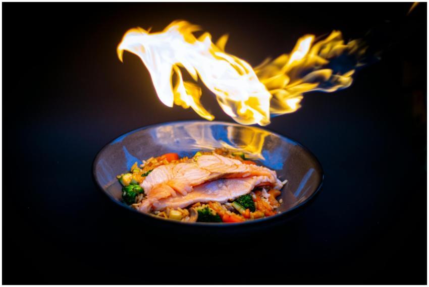 Vibrant flame-grilled salmon served on vegetable f