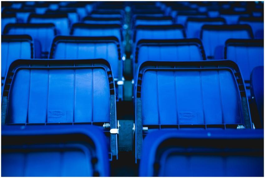 Close-up view of empty blue plastic seats in an ou