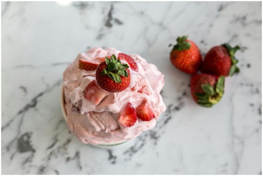A bowl of homemade strawberry ice cream with fresh