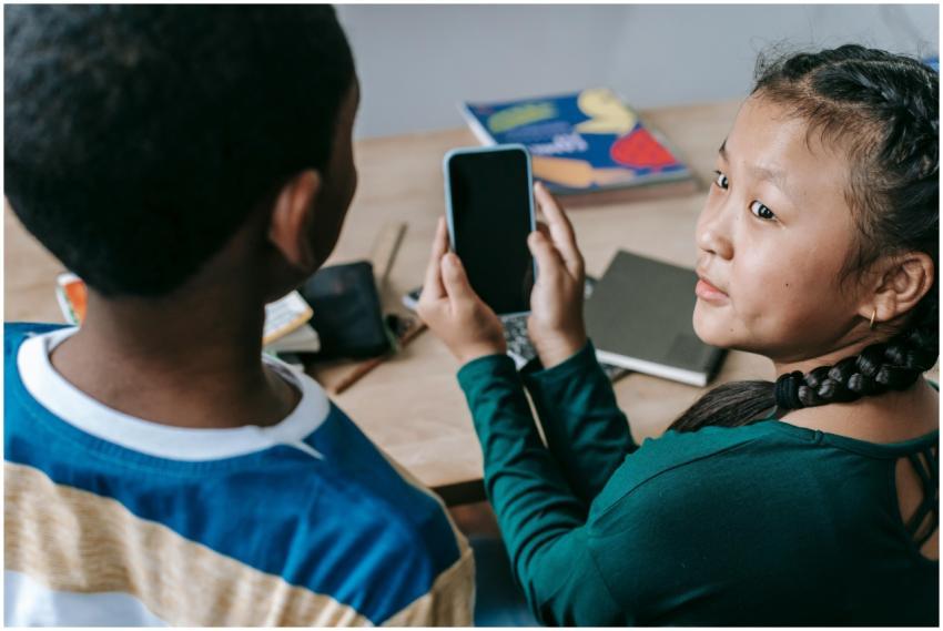 From above of adorable little Asian girl showing m