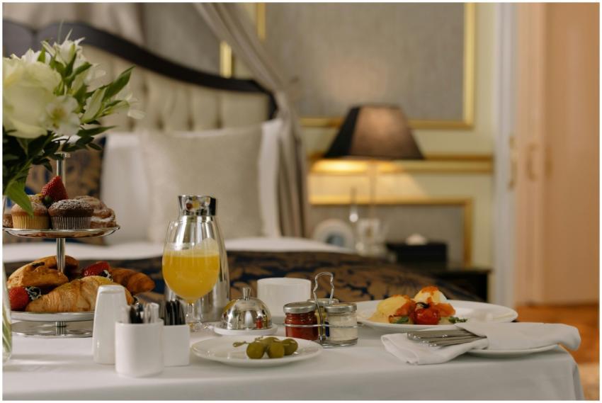 Elegant hotel room breakfast featuring pastries, o