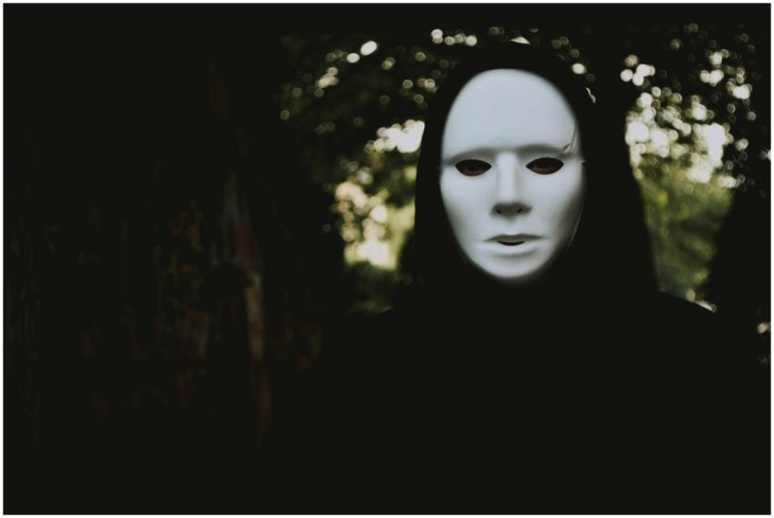 A mysterious figure in a white mask lurking in an