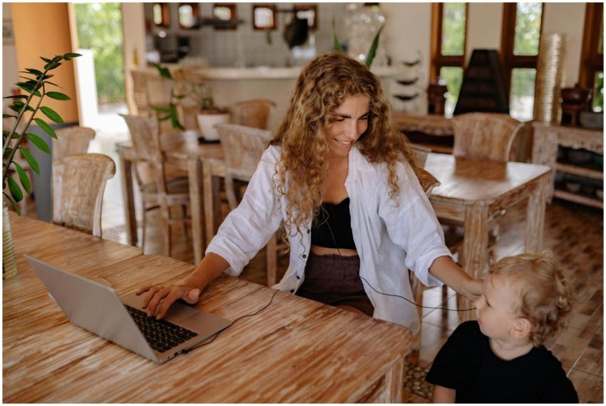 Mother working remotely on a laptop while interact
