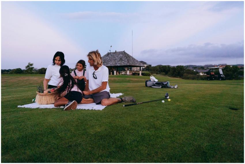A family on a golf course having a picnic during s