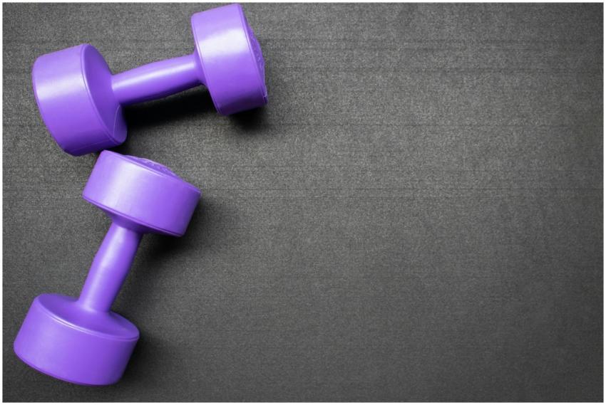 Pair of purple dumbbells on a dark gray background